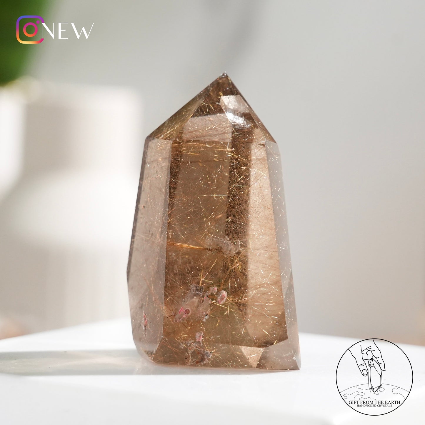 Crystal-in-crystal golden rutilated quartz point with white phantom