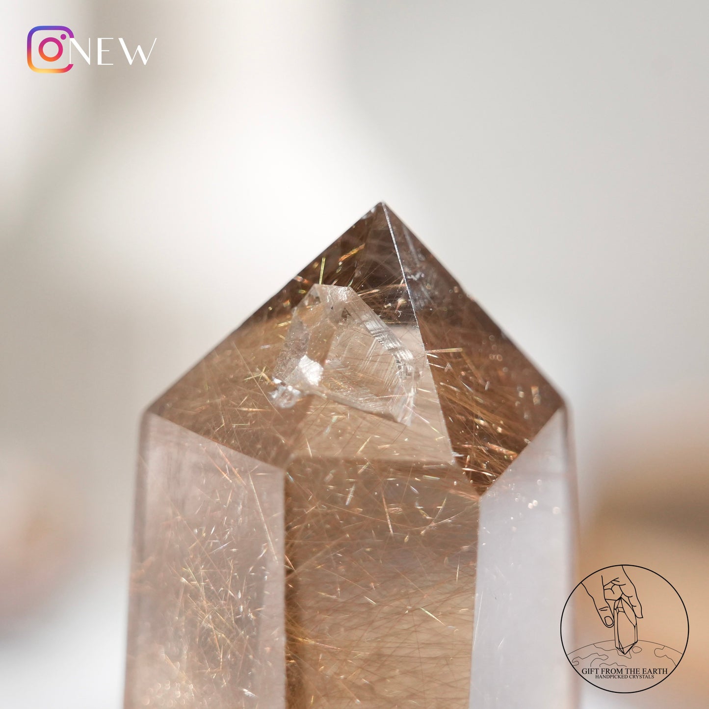 Crystal-in-crystal golden rutilated quartz point with white phantom