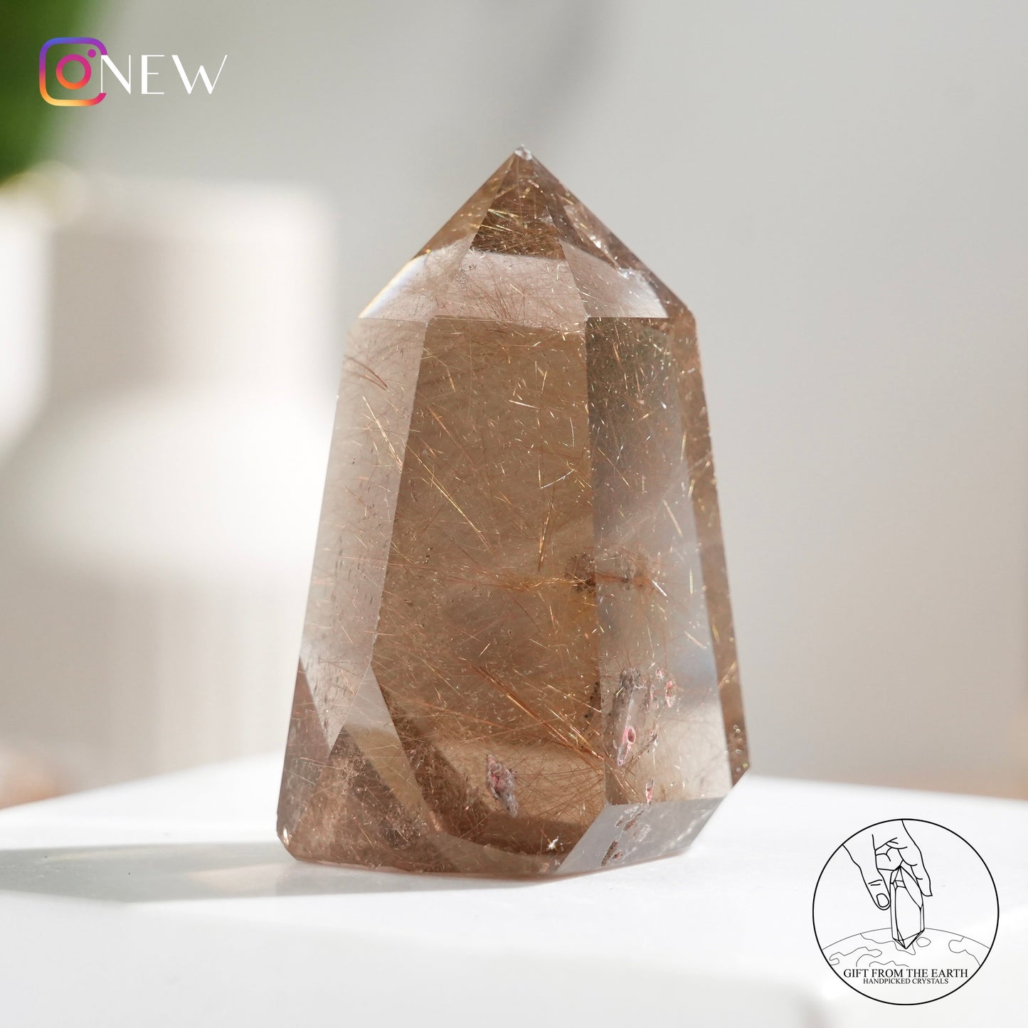 Crystal-in-crystal golden rutilated quartz point with white phantom