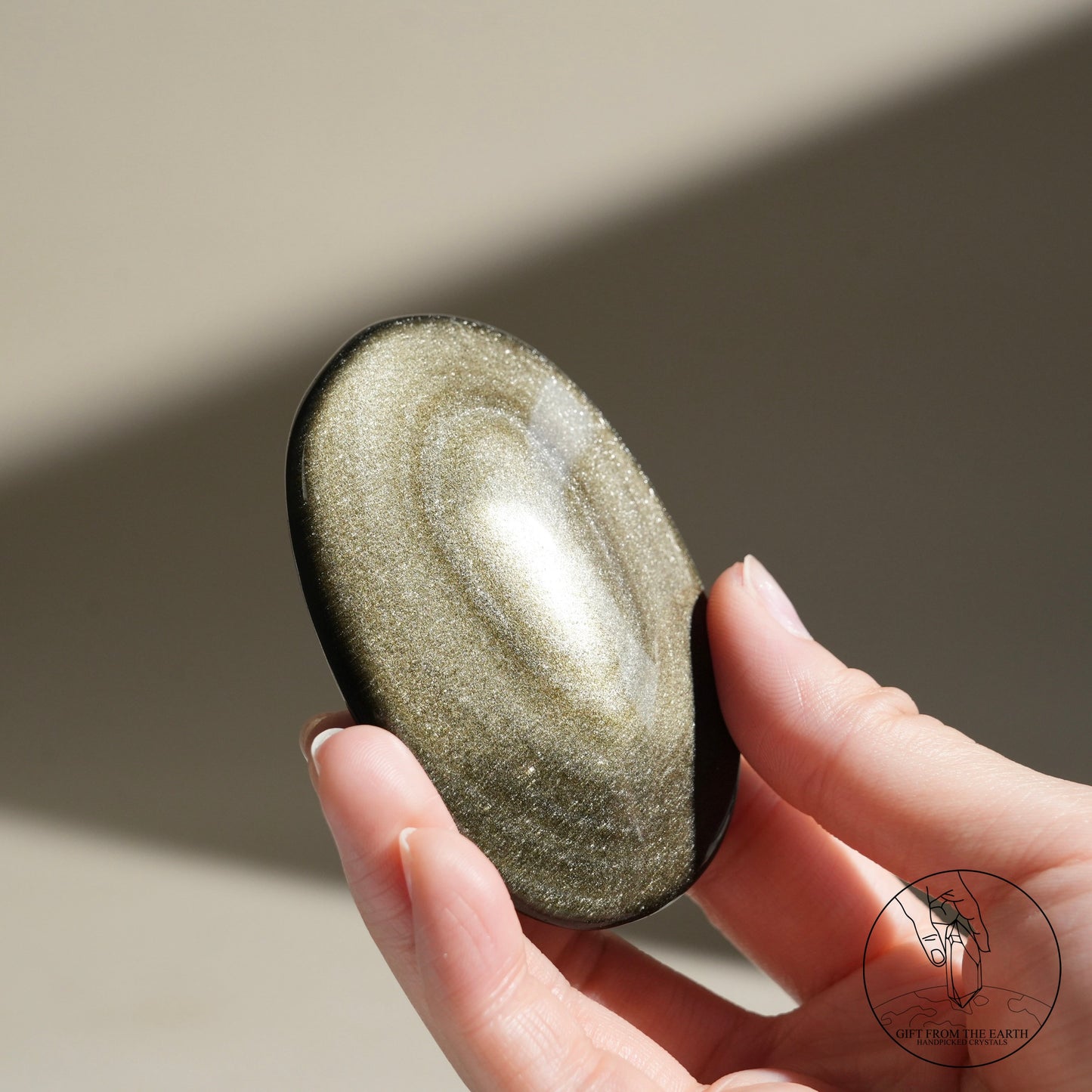 Golden obsidian palm stone