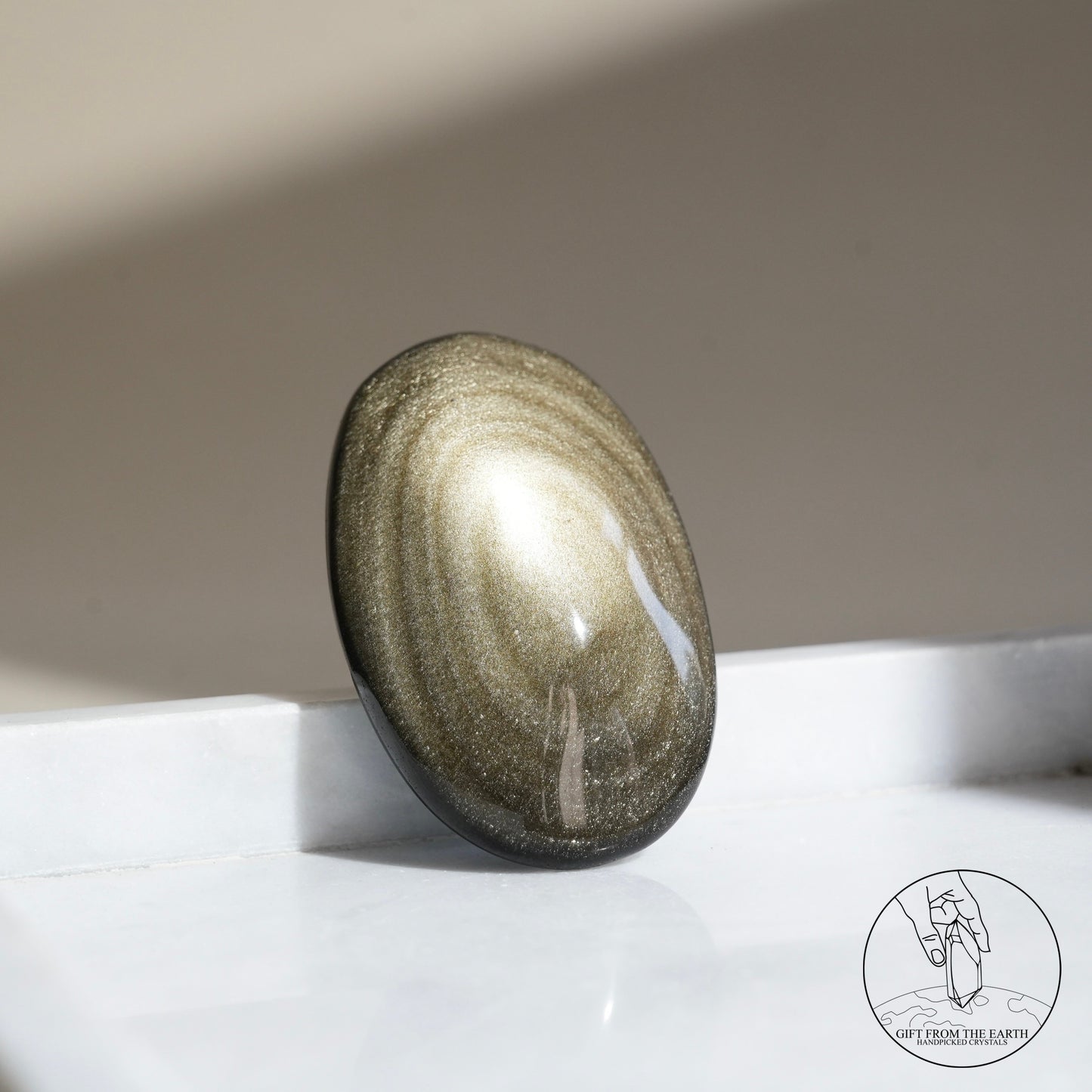 Golden obsidian palm stone