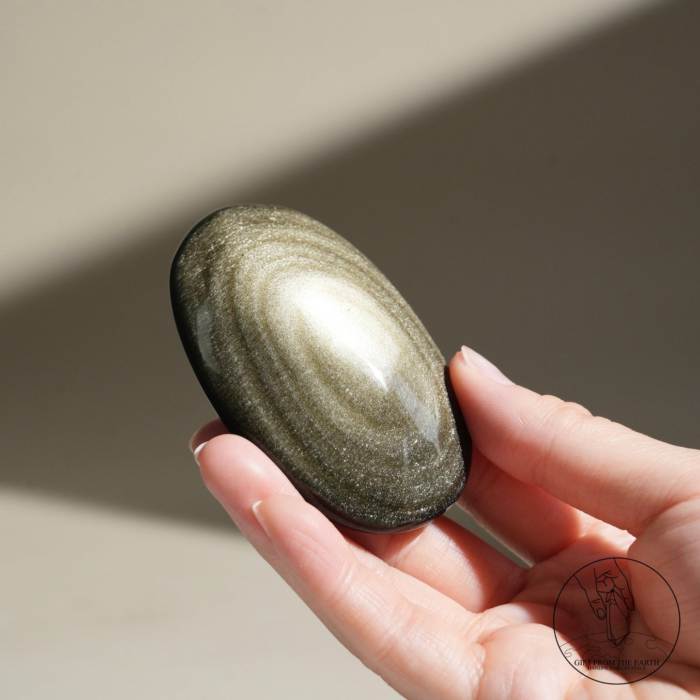 Golden obsidian palm stone