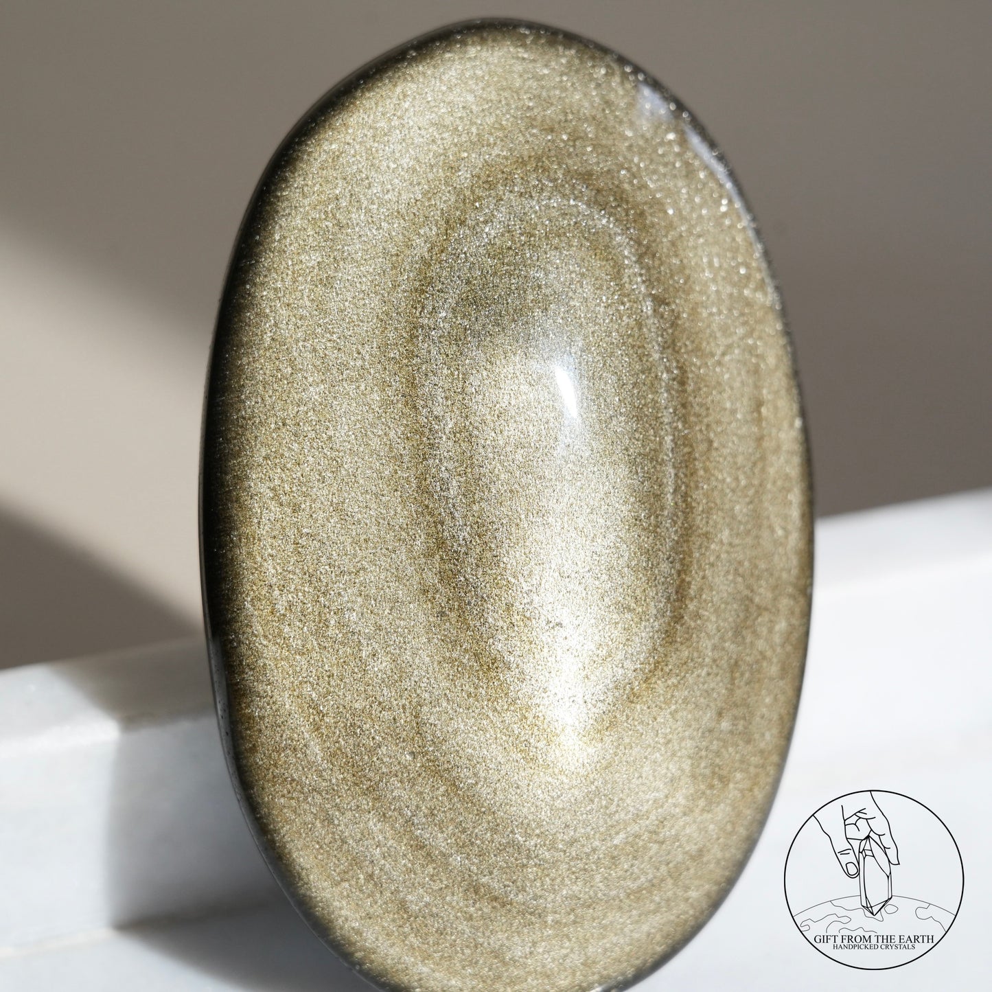 Golden obsidian palm stone